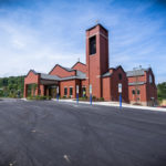 Exterior of St. Kilian Church - red brick church building surrounded by large parking lot